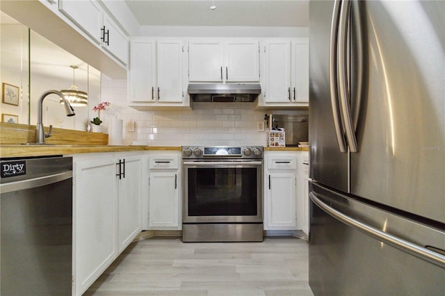 3269 Beneva Rd Unit 103, Sarasota, FL 34232 - kitchen with appliances with stainless steel finishes, exhaust hood, white cabinets, and tasteful backsplash