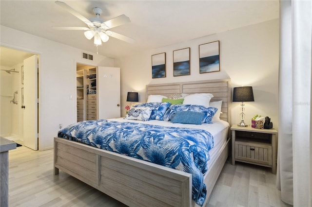 3269 Beneva Rd Unit 103, Sarasota, FL 34232 - bedroom with wood finished floors, ensuite bath, a ceiling fan, and a walk in closet
