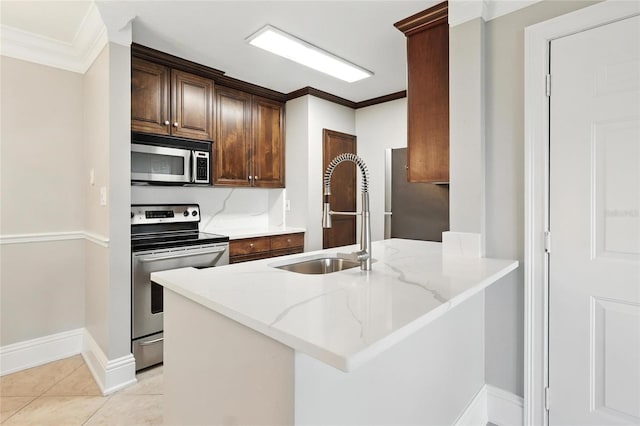 4037 Crockers Lake Blvd Unit 14, Sarasota, FL 34238 - kitchen featuring stainless steel appliances, ornamental molding, a peninsula, light stone counters, and light tile patterned floors