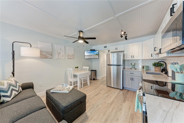 301 Highland Ave Unit 3, Bradenton Beach, FL 34217 - living room featuring a ceiling fan, light wood finished floors, and baseboards