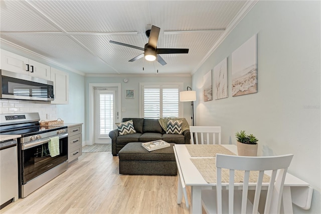 301 Highland Ave Unit 3, Bradenton Beach, FL 34217 - living area featuring a ceiling fan, light wood-style floors, ornamental molding, and baseboards