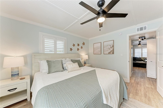 301 Highland Ave Unit 3, Bradenton Beach, FL 34217 - bedroom with light wood-type flooring, ornamental molding, a ceiling fan, and baseboards