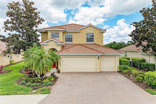mediterranean / spanish home featuring stucco siding, a tile roof, and decorative driveway