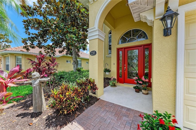 view of exterior entry featuring stucco siding and a porch