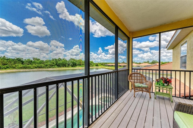 sunroom featuring a water view