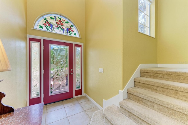 tiled entrance foyer with stairway and baseboards