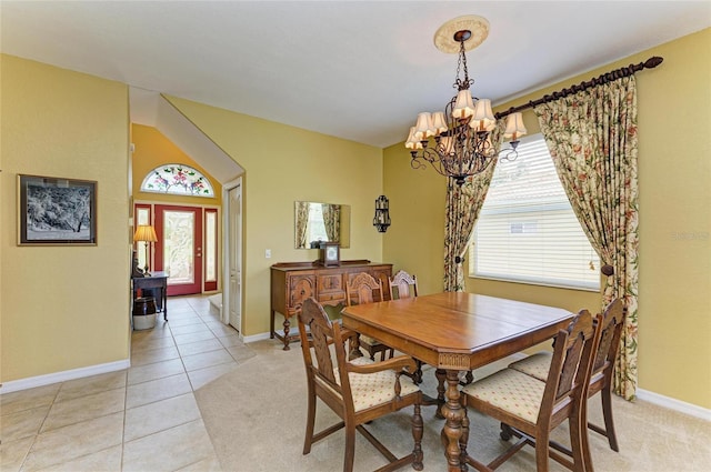 dining space with a chandelier, baseboards, light tile patterned floors, and light carpet
