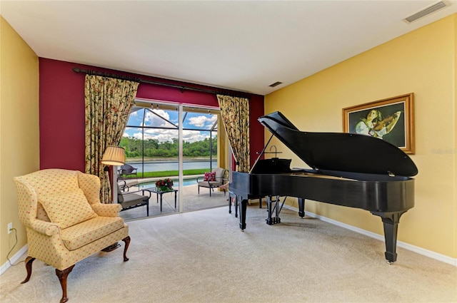 living area featuring carpet floors, baseboards, and a water view