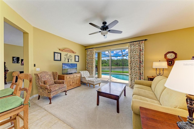 living room with a ceiling fan, light carpet, and baseboards