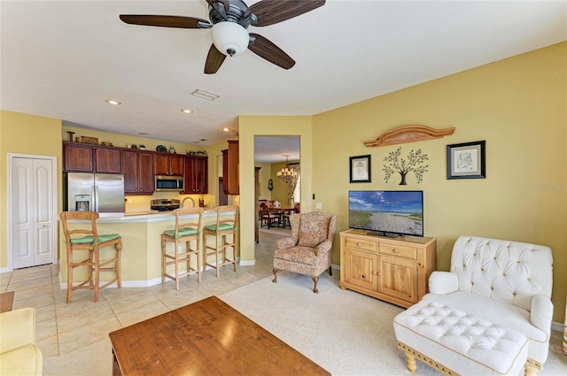 living room featuring light tile patterned floors, baseboards, a chandelier, recessed lighting, and a ceiling fan