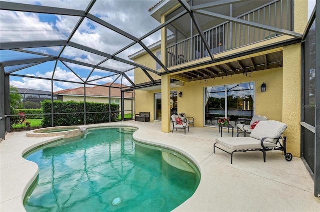 view of pool featuring a patio, a pool with connected hot tub, and glass enclosure