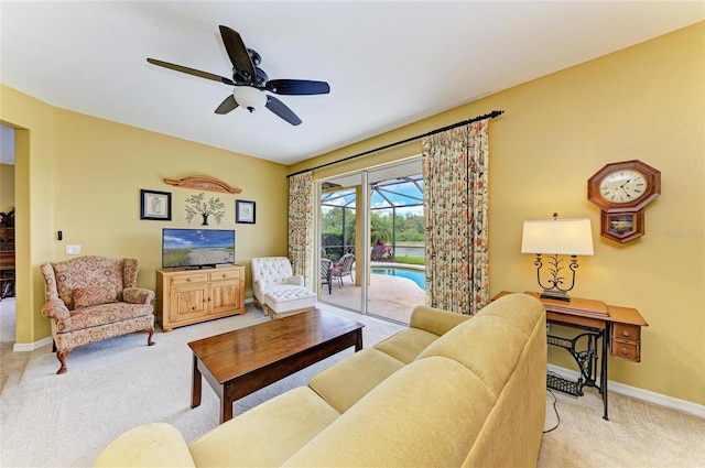 living area featuring light carpet, a ceiling fan, and baseboards