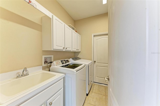 laundry area with cabinet space, washer and clothes dryer, and light tile patterned floors
