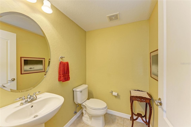 bathroom featuring a sink, toilet, tile patterned flooring, and baseboards