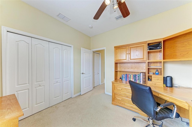 home office with light carpet, a ceiling fan, and baseboards