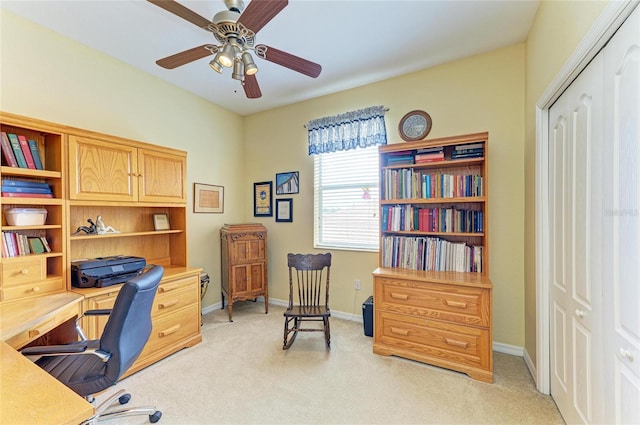 office featuring light carpet, a ceiling fan, and baseboards