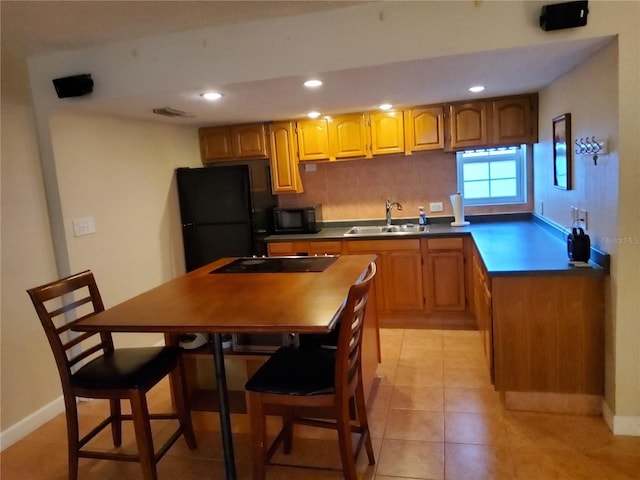 4607 W N B St Unit 105, Tampa, FL 33609 - kitchen featuring black appliances, recessed lighting, light tile patterned flooring, and brown cabinets