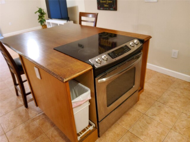 4607 W N B St Unit 105, Tampa, FL 33609 - kitchen featuring electric stove, light tile patterned flooring, and a breakfast bar