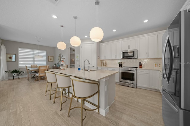 6185 SW 89th Ct, Ocala, FL 34481 - kitchen featuring stainless steel appliances, a sink, light countertops, light wood-type flooring, and recessed lighting