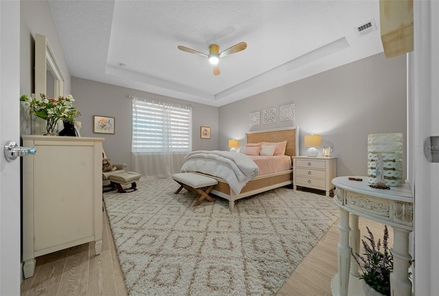 6185 SW 89th Ct, Ocala, FL 34481 - bedroom with light wood-style flooring, a raised ceiling, and ceiling fan