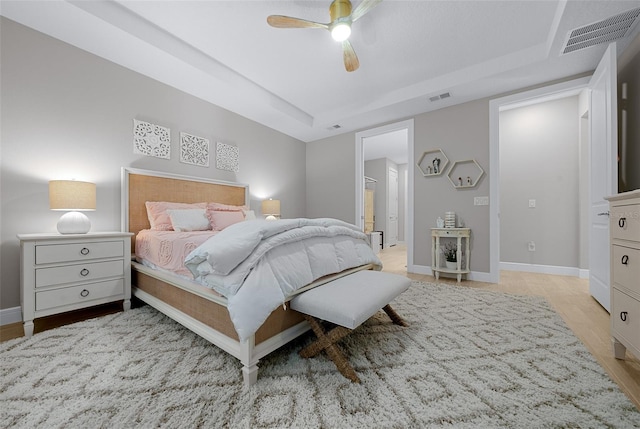 6185 SW 89th Ct, Ocala, FL 34481 - bedroom with a ceiling fan, baseboards, light wood-style flooring, and a tray ceiling