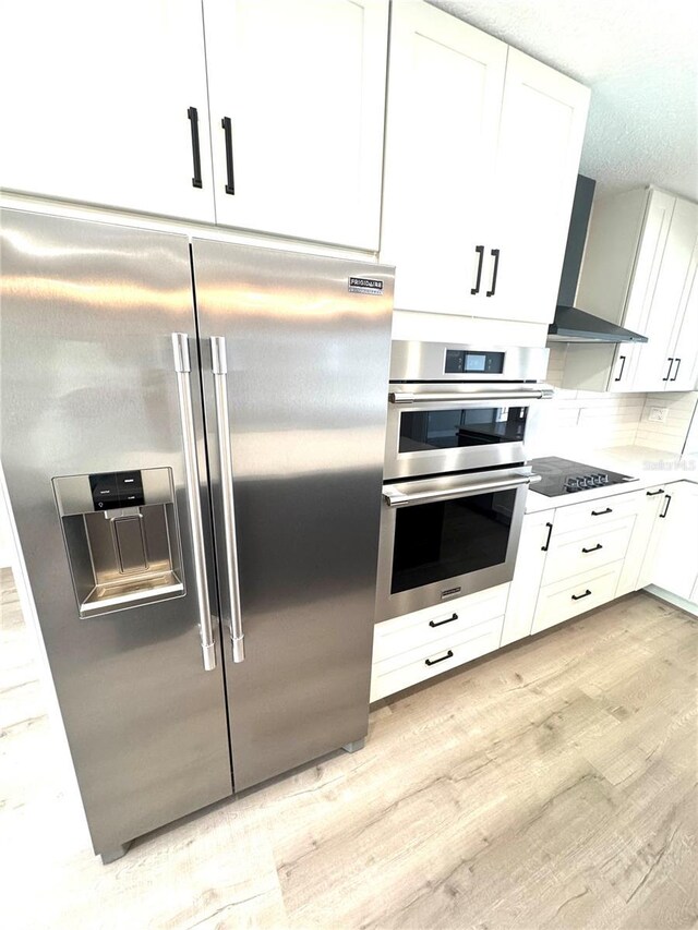 6524 Senegal Palm Way, Apollo Beach, FL 33572 - kitchen with stainless steel appliances, wall chimney range hood, light wood-style floors, white cabinets, and light countertops