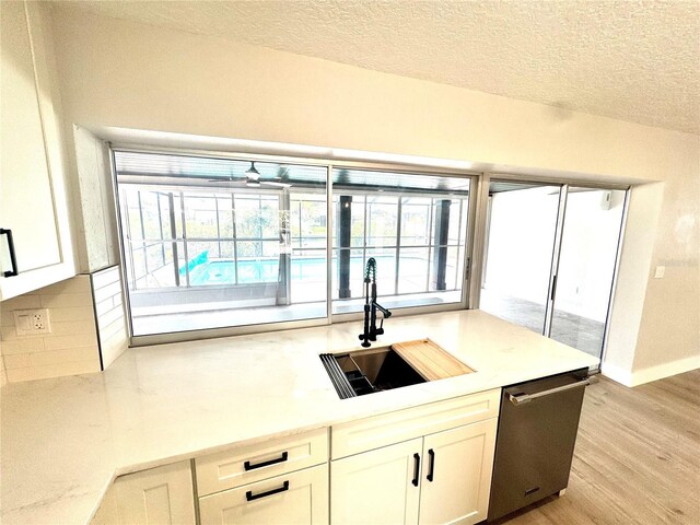 6524 Senegal Palm Way, Apollo Beach, FL 33572 - kitchen featuring a sink, dishwasher, backsplash, light wood-style floors, and white cabinetry