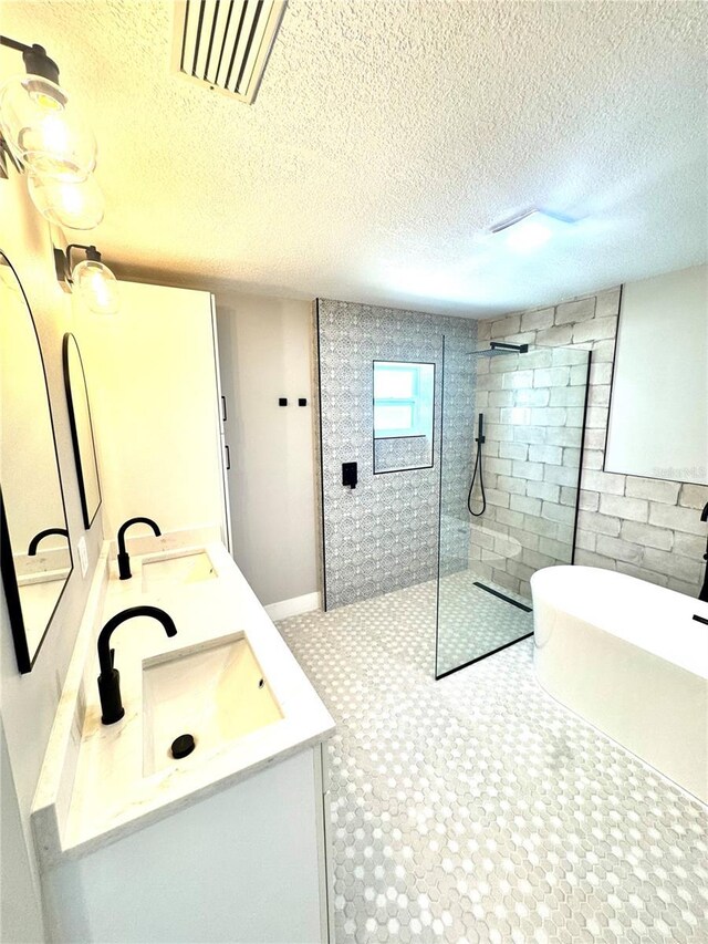 6524 Senegal Palm Way, Apollo Beach, FL 33572 - bathroom with walk in shower, a textured ceiling, double vanity, and a freestanding bath