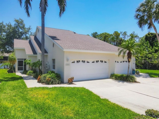 6222 Country Club Way, Sarasota, FL 34243 - view of front of house featuring stucco siding, an attached garage, driveway, and a front lawn