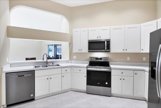 6222 Country Club Way, Sarasota, FL 34243 - kitchen featuring appliances with stainless steel finishes, a sink, light countertops, white cabinets, and a towering ceiling