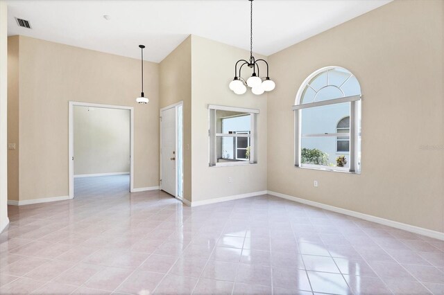 6222 Country Club Way, Sarasota, FL 34243 - empty room with light tile patterned floors, a chandelier, baseboards, and a towering ceiling