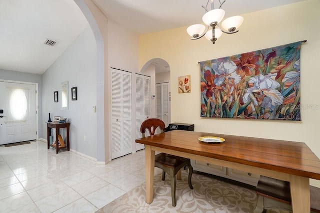 dining area with arched walkways, a chandelier, baseboards, and vaulted ceiling