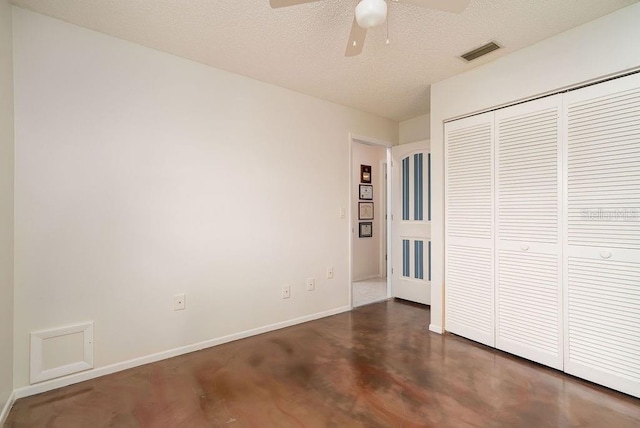unfurnished bedroom with baseboards, a closet, finished concrete floors, a ceiling fan, and a textured ceiling