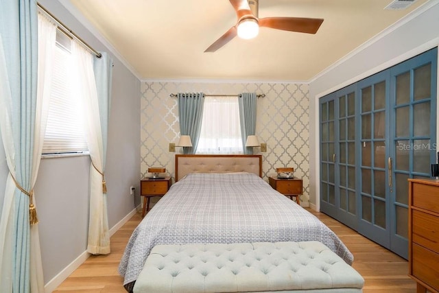 bedroom with wallpapered walls, ornamental molding, wood finished floors, baseboards, and a ceiling fan