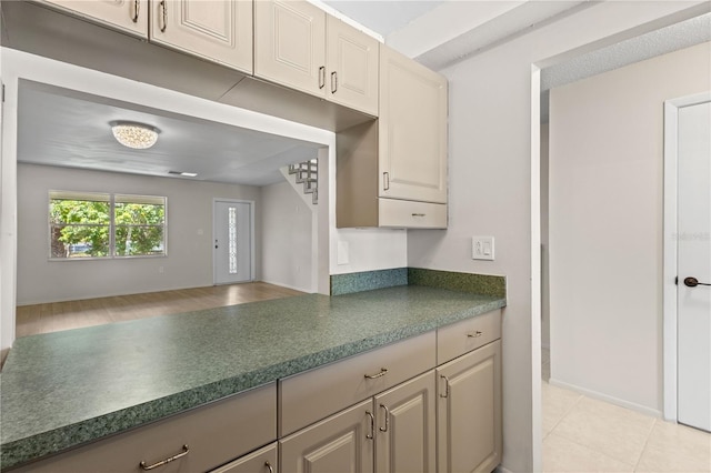 3212 Ramblewood Dr N Unit 3212, Sarasota, FL 34237 - kitchen featuring dark countertops, baseboards, and cream cabinets