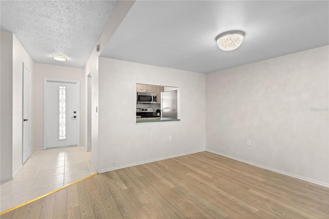 3212 Ramblewood Dr N Unit 3212, Sarasota, FL 34237 - entryway with light wood-style floors, baseboards, and a textured ceiling