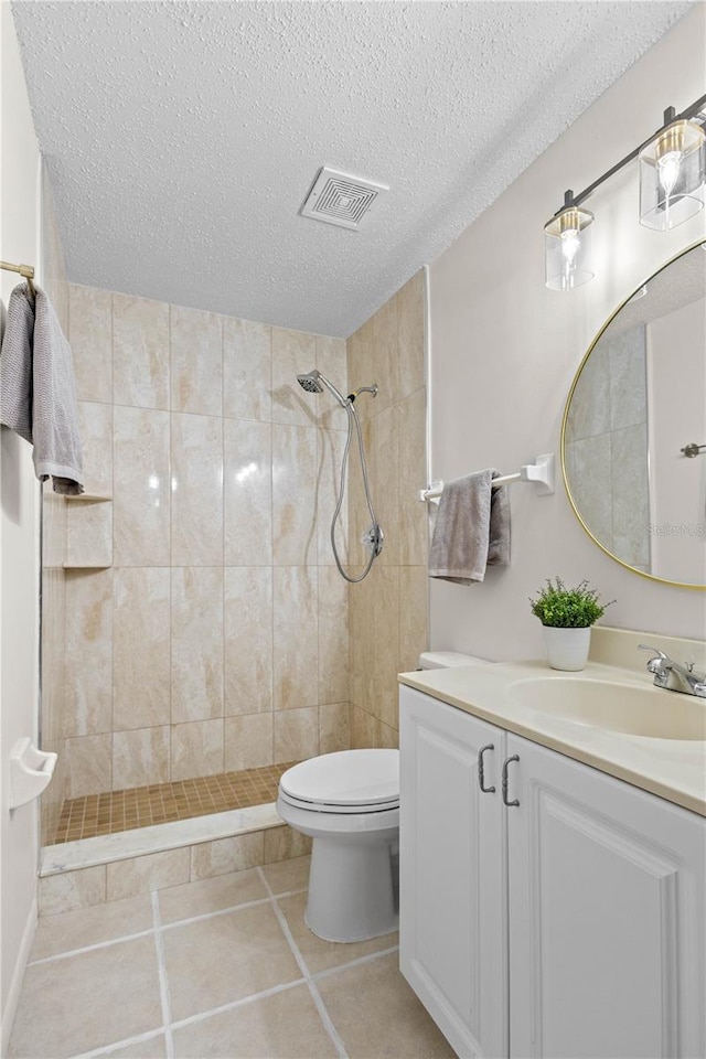 3212 Ramblewood Dr N Unit 3212, Sarasota, FL 34237 - full bath featuring vanity, toilet, a tile shower, a textured ceiling, and tile patterned floors