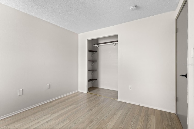 3212 Ramblewood Dr N Unit 3212, Sarasota, FL 34237 - unfurnished bedroom featuring wood finished floors, a textured ceiling, a closet, and baseboards
