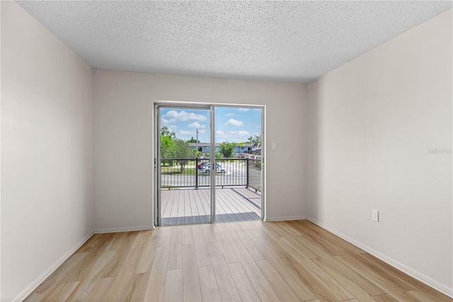 3212 Ramblewood Dr N Unit 3212, Sarasota, FL 34237 - empty room with light wood-type flooring, a textured ceiling, and baseboards