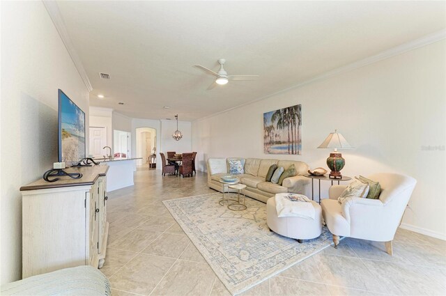 24065 Canterwood Way, Venice, FL 34293 - living room with crown molding, arched walkways, a ceiling fan, light tile patterned floors, and baseboards