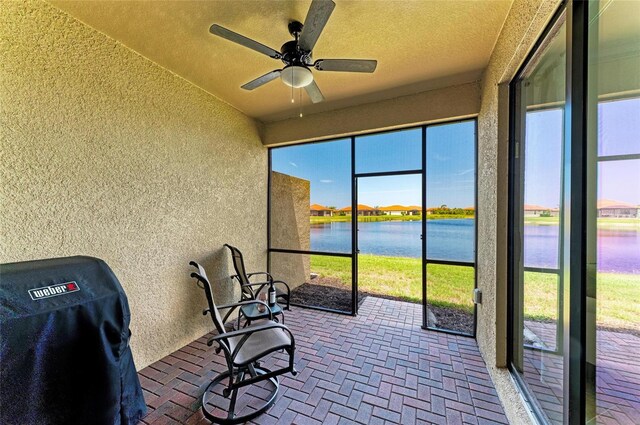 24065 Canterwood Way, Venice, FL 34293 - unfurnished sunroom with a textured wall, a water view, ceiling fan, lofted ceiling, and brick patterned floors