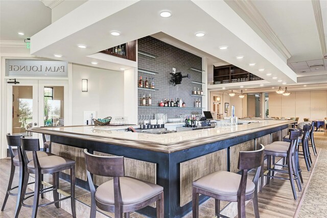 24065 Canterwood Way, Venice, FL 34293 - indoor wet bar featuring ornamental molding, light wood-style flooring, french doors, and recessed lighting