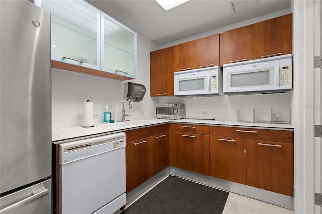 1350 Main St Unit 1703, Sarasota, FL 34236 - kitchen featuring white appliances, a sink, light countertops, and brown cabinets