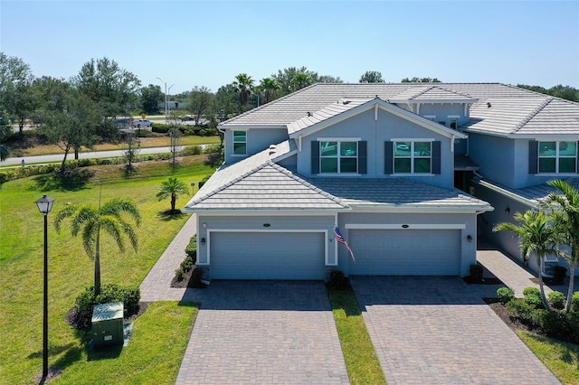 1017 Tidewater Shores Loop Unit 1017, Bradenton, FL 34208 - view of front of home featuring a tile roof, driveway, a garage, and a front yard