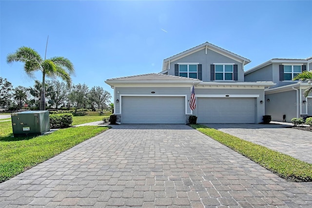 1017 Tidewater Shores Loop Unit 1017, Bradenton, FL 34208 - traditional-style house featuring decorative driveway, a garage, stucco siding, and a front lawn