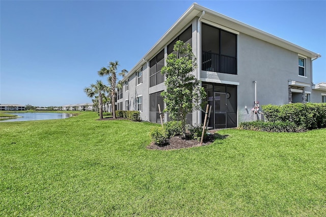 1017 Tidewater Shores Loop Unit 1017, Bradenton, FL 34208 - rear view of house with stucco siding, a water view, and a yard