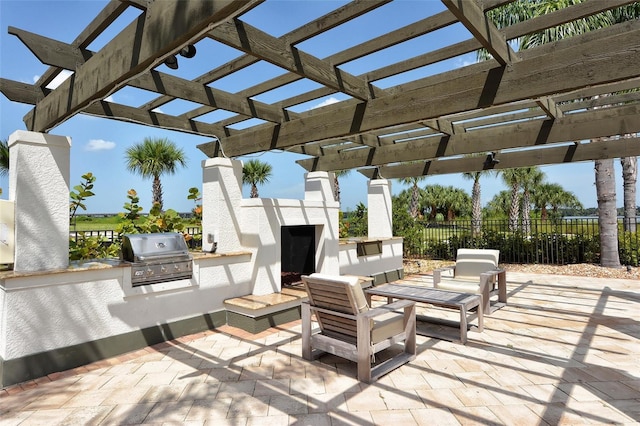 1017 Tidewater Shores Loop Unit 1017, Bradenton, FL 34208 - view of patio featuring grilling area, exterior kitchen, fence, exterior fireplace, and a pergola