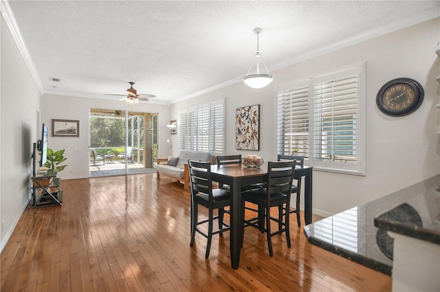 8525 54th Avenue Cir E, Bradenton, FL 34211 - dining space featuring a ceiling fan, wood-type flooring, ornamental molding, baseboards, and a textured ceiling