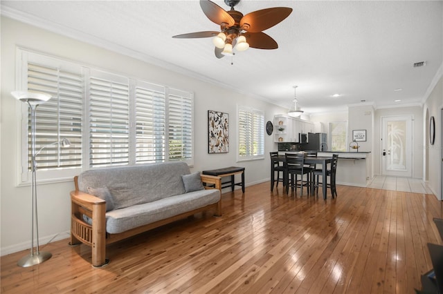 8525 54th Avenue Cir E, Bradenton, FL 34211 - living area featuring a ceiling fan, light wood finished floors, crown molding, and baseboards