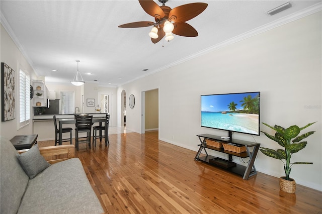 8525 54th Avenue Cir E, Bradenton, FL 34211 - living area featuring ornamental molding, light wood-style floors, ceiling fan, baseboards, and arched walkways